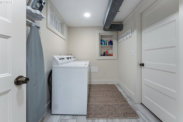 laundry area featuring light wood-type flooring, laundry area, washer and clothes dryer, and baseboards