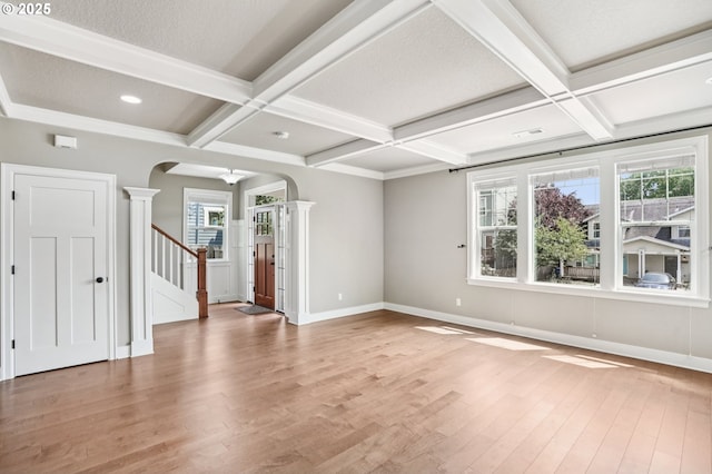 665 NE Skidmore St, Portland, OR 97211 - spare room featuring decorative columns, arched walkways, coffered ceiling, wood finished floors, and plenty of natural light