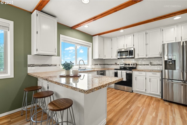 20740 S Shelley Ln, Beavercreek, OR 97004 - kitchen with stainless steel appliances, backsplash, white cabinetry, beamed ceiling, and recessed lighting