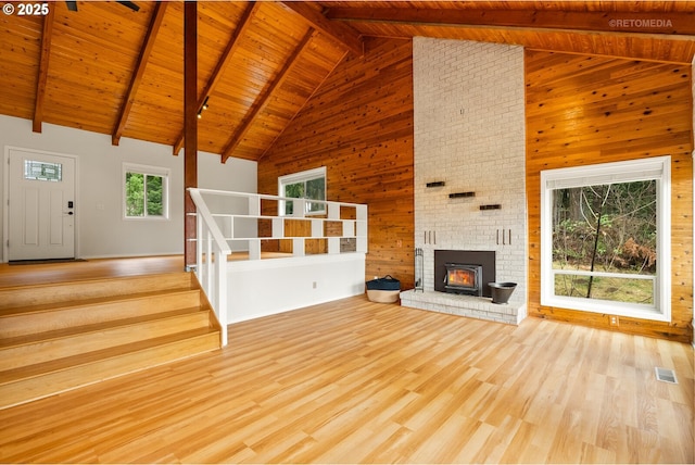 20740 S Shelley Ln, Beavercreek, OR 97004 - unfurnished living room featuring high vaulted ceiling, a wood ceiling with exposed beams, wood walls, wood finished floors, and stairway