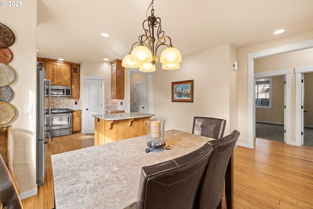 dining room featuring recessed lighting, baseboards, light wood-style floors, and a chandelier