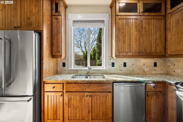 kitchen with a sink, stainless steel appliances, and brown cabinetry