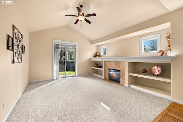 unfurnished living room with baseboards, plenty of natural light, a fireplace, and vaulted ceiling