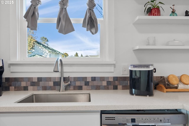 details featuring dishwashing machine, sink, and backsplash