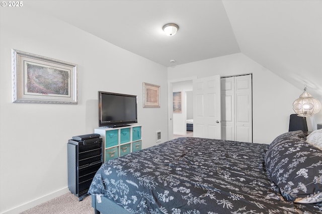 carpeted bedroom featuring vaulted ceiling and a closet