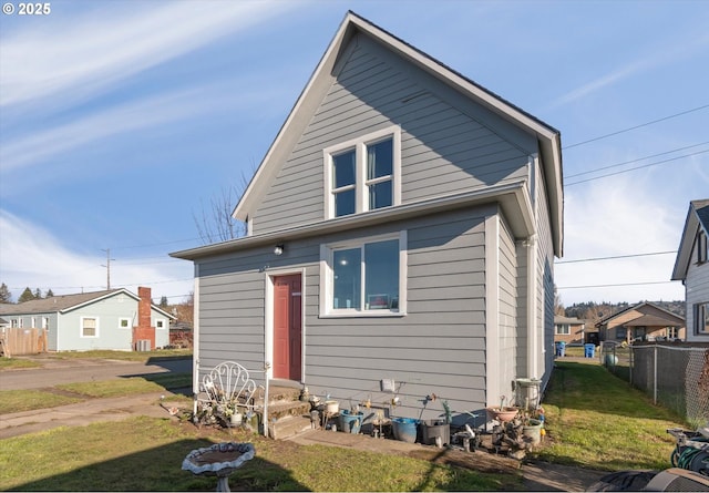 rear view of property featuring a lawn