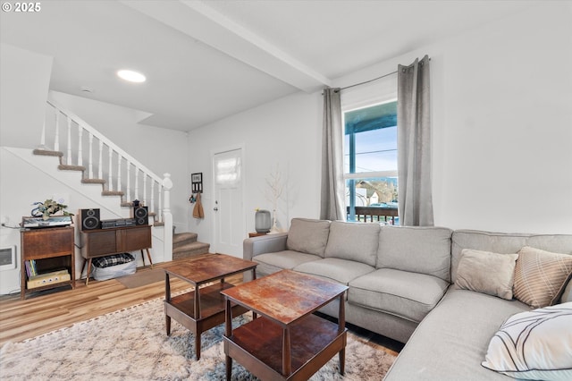 living room with light hardwood / wood-style flooring and beamed ceiling