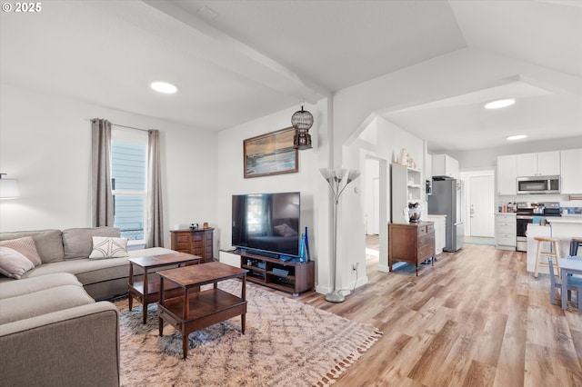 living room with vaulted ceiling and light hardwood / wood-style flooring