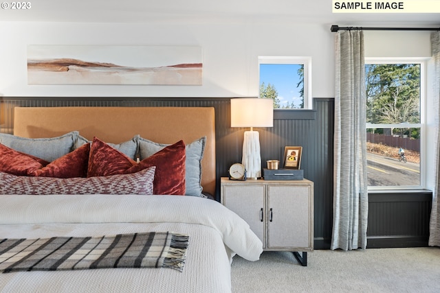 bedroom featuring a wainscoted wall, carpet flooring, and wood walls