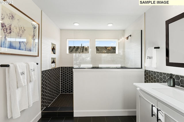 bathroom with vanity, baseboards, walk in shower, and tile patterned floors