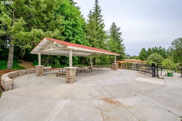 view of property's community featuring fence, a gazebo, and a patio