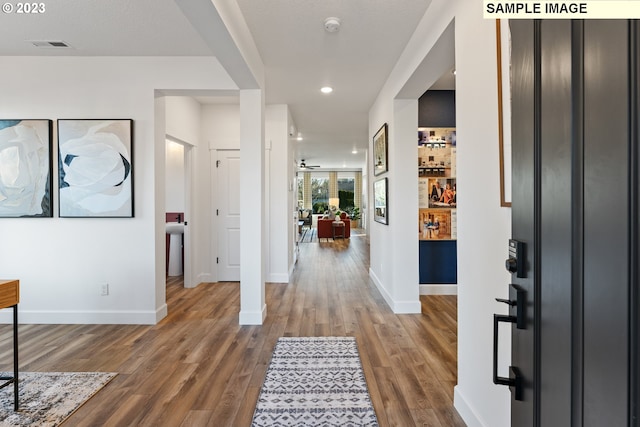 foyer entrance featuring visible vents, baseboards, wood finished floors, and recessed lighting