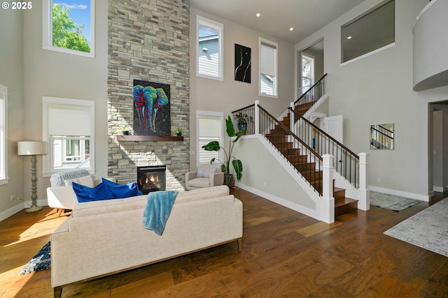 living area featuring a fireplace, wood finished floors, and a high ceiling