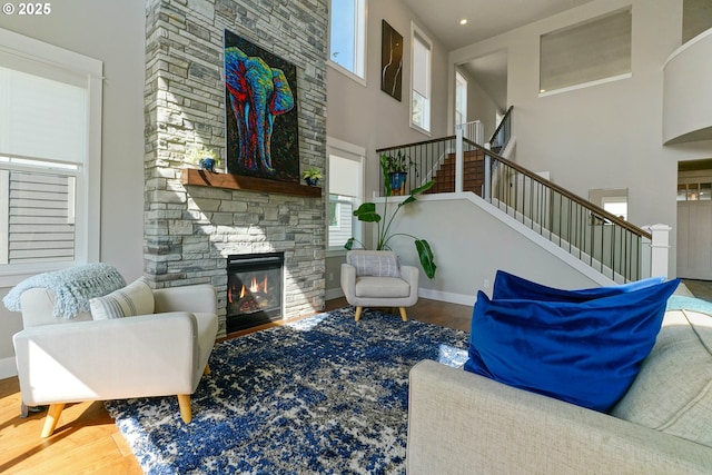 living room featuring a fireplace, stairway, and a healthy amount of sunlight