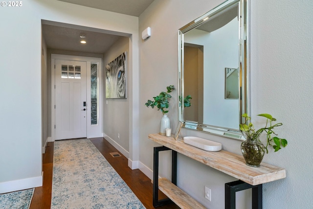 foyer featuring dark wood-style floors and baseboards