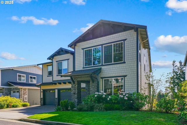 craftsman-style home featuring a front lawn, driveway, stone siding, and a garage