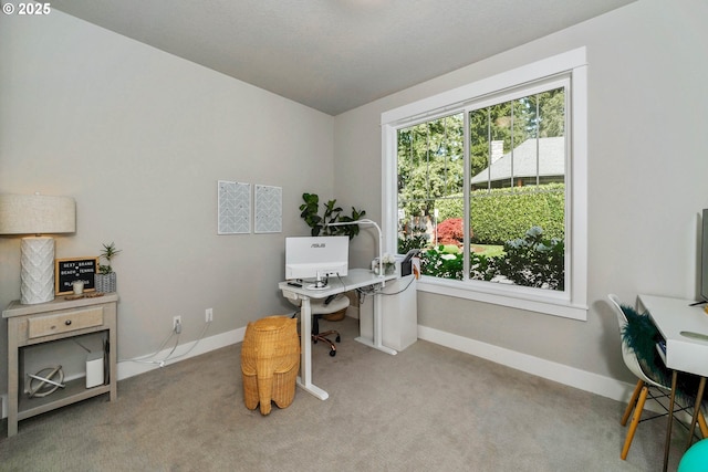 carpeted home office featuring baseboards