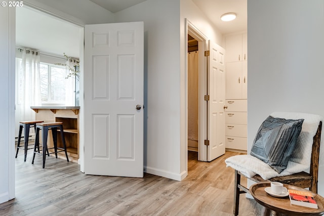 sitting room featuring light wood-style flooring, baseboards, and baseboard heating