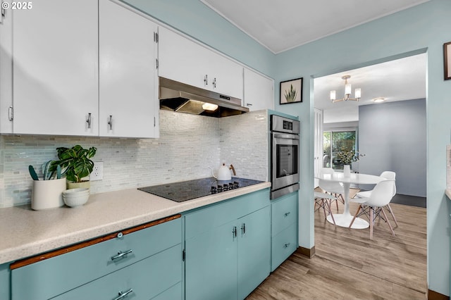 kitchen with light countertops, light wood-style flooring, stainless steel oven, under cabinet range hood, and black electric cooktop