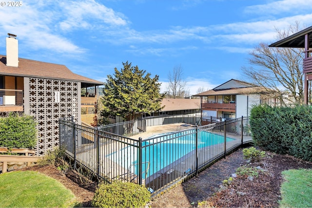 community pool with a patio and fence