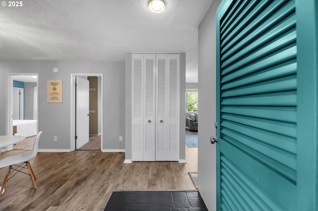 interior space featuring a textured ceiling, baseboards, and wood finished floors