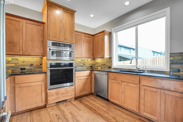 16099 SE Venice Ridge Way, Damascus, OR 97089 - kitchen with stainless steel appliances, dark stone countertops, backsplash, light wood-style floors, and recessed lighting