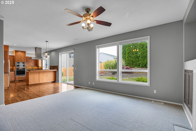 16099 SE Venice Ridge Way, Damascus, OR 97089 - unfurnished living room featuring healthy amount of natural light, carpet floors, and a ceiling fan