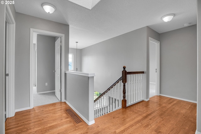 16099 SE Venice Ridge Way, Damascus, OR 97089 - corridor featuring an upstairs landing, wood finished floors, and a textured ceiling