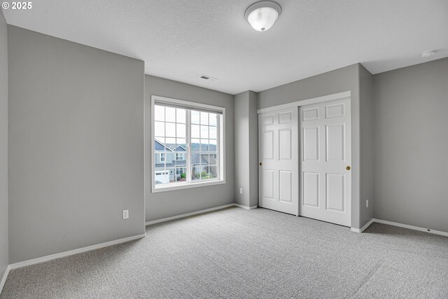16099 SE Venice Ridge Way, Damascus, OR 97089 - unfurnished bedroom with carpet floors, a closet, and a textured ceiling