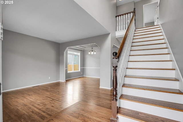 16099 SE Venice Ridge Way, Damascus, OR 97089 - staircase featuring wood finished floors, arched walkways, and a chandelier