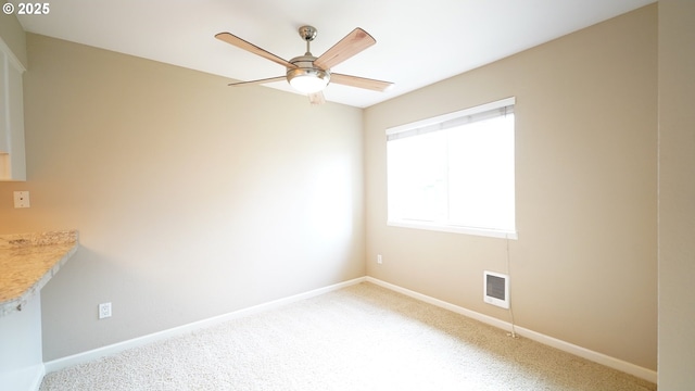 unfurnished room with a ceiling fan, carpet, visible vents, and baseboards