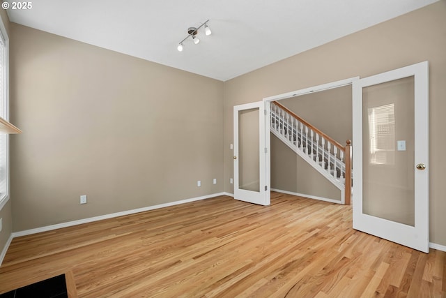 2475 NE 10th Ave, Hillsboro, OR 97124 - empty room featuring french doors, light wood-style flooring, stairs, and baseboards