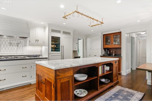 2505 SW Hillcrest Dr, Portland, OR 97201 - kitchen with stainless steel gas cooktop, open shelves, a center island, backsplash, and glass insert cabinets
