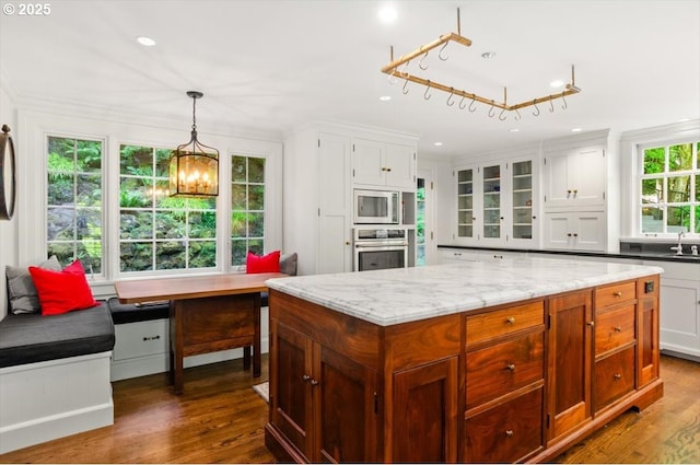 2505 SW Hillcrest Dr, Portland, OR 97201 - kitchen with appliances with stainless steel finishes, white cabinets, a chandelier, dark wood finished floors, and ornamental molding