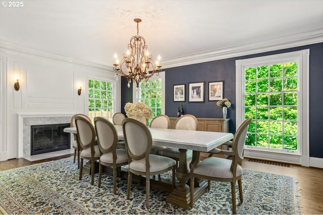 2505 SW Hillcrest Dr, Portland, OR 97201 - dining area featuring a chandelier, wood finished floors, ornamental molding, and a fireplace