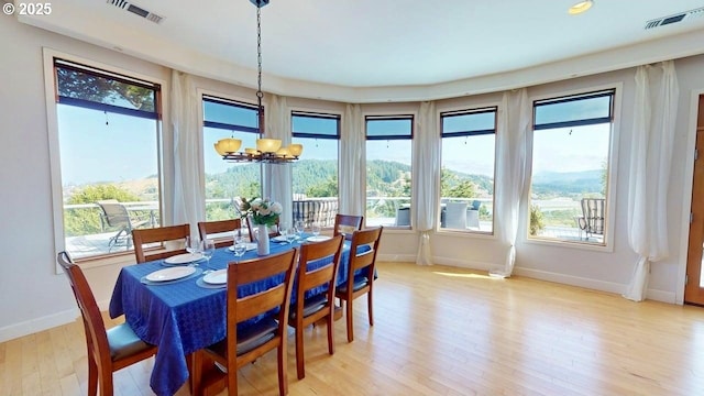 94414 Tom Cat Hill Rd, Gold Beach, OR 97444 - dining space with a chandelier, light wood-style flooring, and plenty of natural light