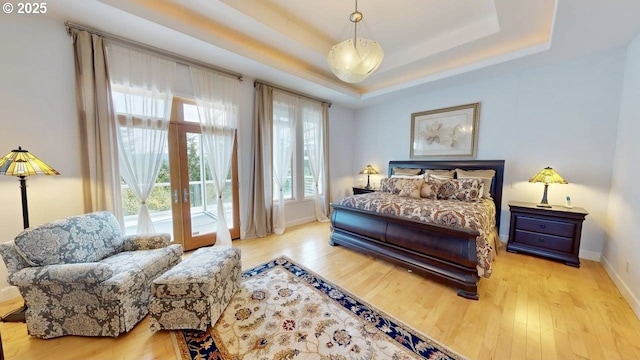 94414 Tom Cat Hill Rd, Gold Beach, OR 97444 - bedroom featuring wood finished floors, a tray ceiling, access to exterior, and french doors