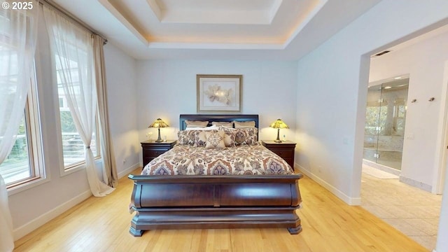 94414 Tom Cat Hill Rd, Gold Beach, OR 97444 - bedroom with a raised ceiling, wood finished floors, and ensuite bath