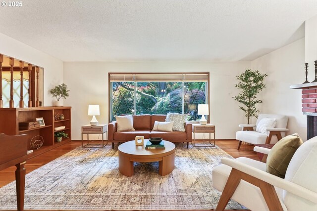 living room featuring a textured ceiling, wood finished floors, and a fireplace