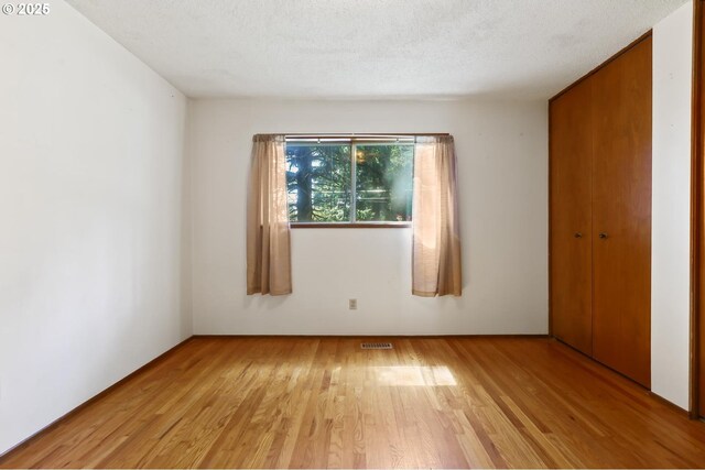 unfurnished room with visible vents and light wood-style flooring