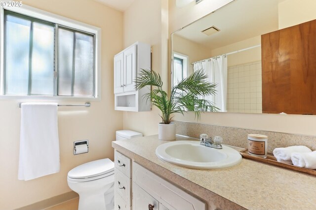 bathroom with toilet, curtained shower, and vanity