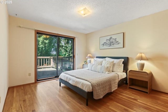 bedroom with a textured ceiling, access to outside, baseboards, and wood finished floors