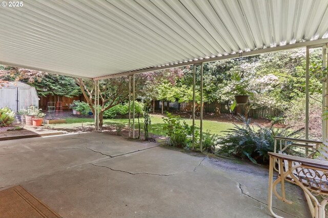 view of patio / terrace with a storage unit, a fenced backyard, and an outbuilding