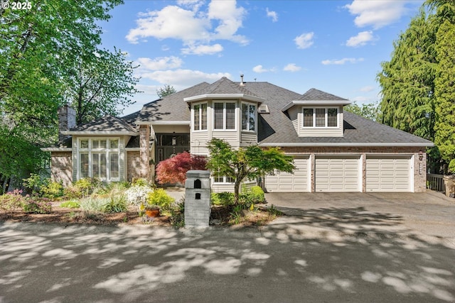 view of front of property featuring concrete driveway, brick siding, a garage, and a shingled roof