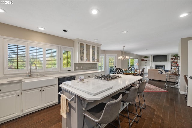 18280 Delenka Ln, Lake Oswego, OR 97034 - kitchen featuring a sink, stainless steel gas cooktop, a center island, a kitchen breakfast bar, and glass insert cabinets