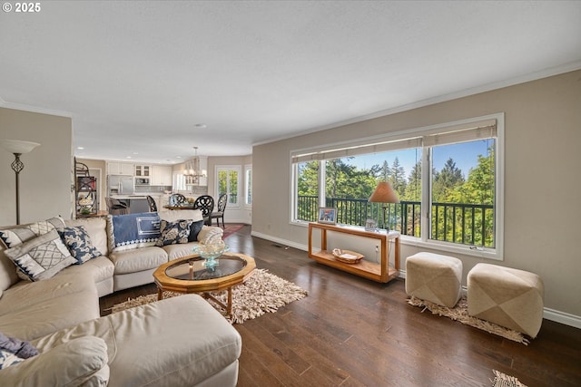 living area with a chandelier, baseboards, crown molding, wood finished floors, and recessed lighting