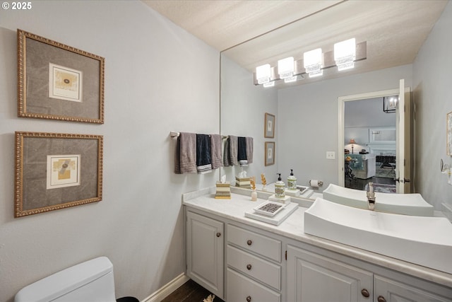 bathroom featuring toilet, vanity, and baseboards