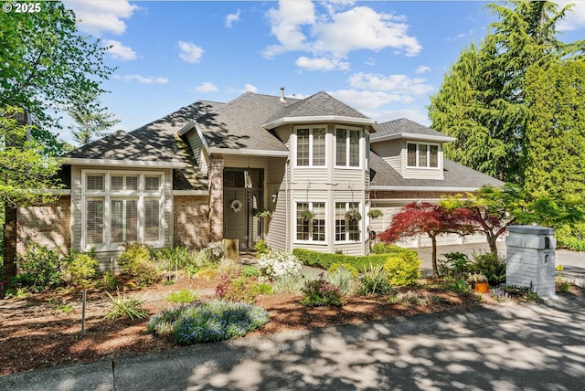 view of front of house featuring brick siding and a shingled roof