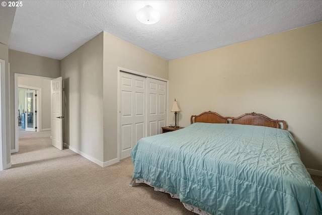 bedroom with carpet floors, a closet, a textured ceiling, and baseboards