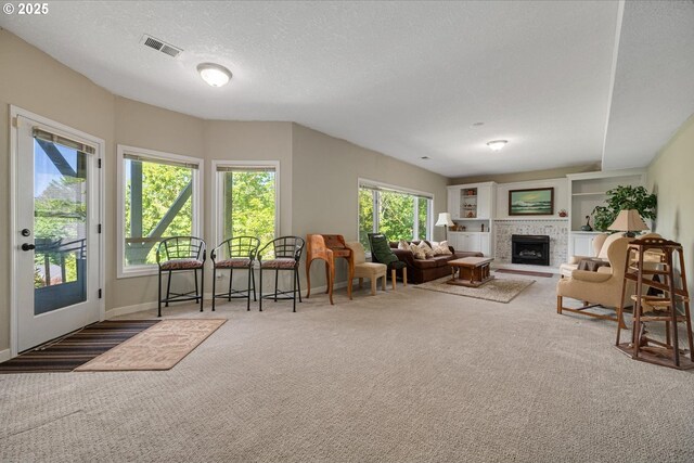 carpeted living room with a fireplace, a textured ceiling, and baseboards